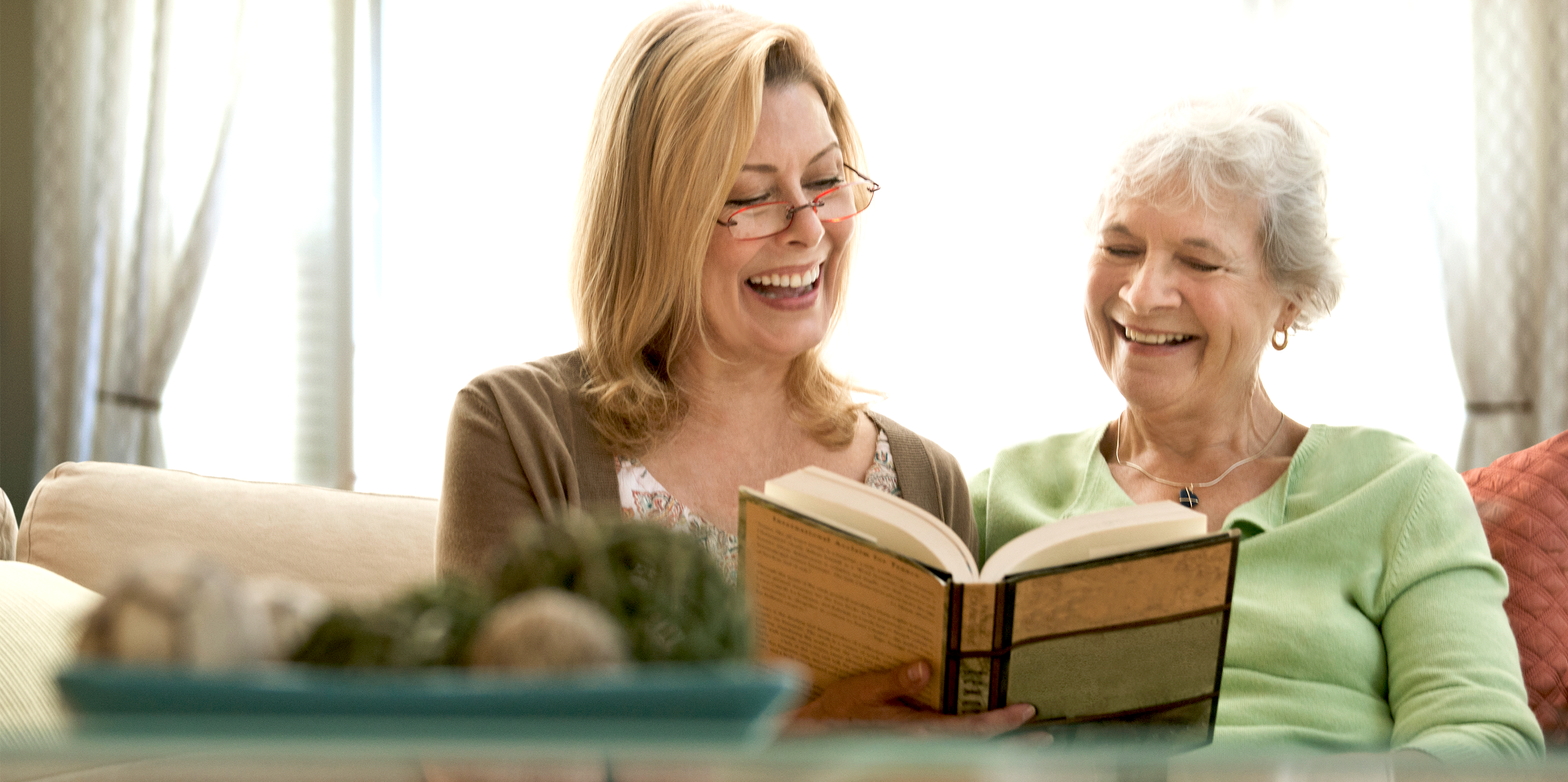 Aide with elder senior woman reading together, primary caregiver support, private duty.