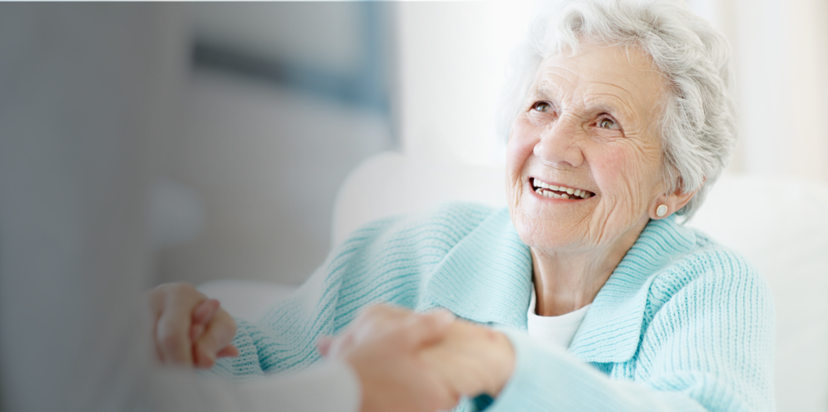 Elderly senior woman being seen by geriatric nurse, nursing home, long-term care